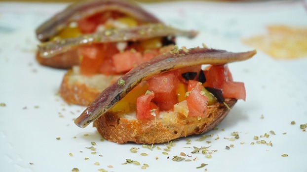 Canapé de anchoa ahumada con tomate, pimiento y orégano